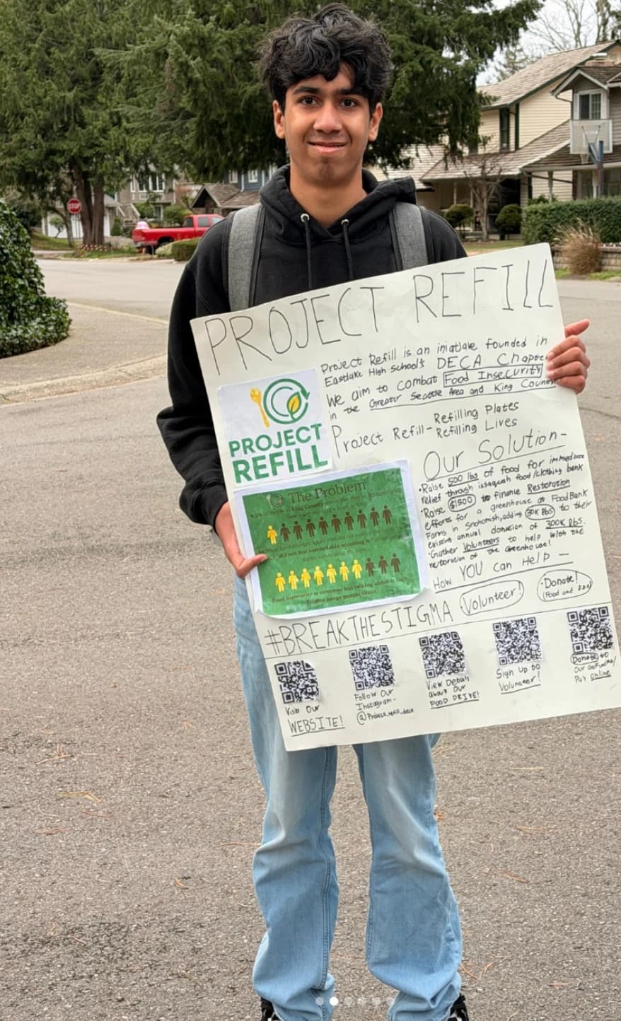 Founder holding a Project Refill sign outside Brown Bear Car Wash